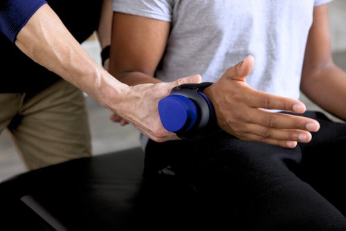 A man receives a therapeutic arm massage from a professional therapist in a calming environment.